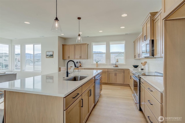 kitchen featuring a sink, decorative backsplash, light countertops, light brown cabinetry, and stainless steel appliances