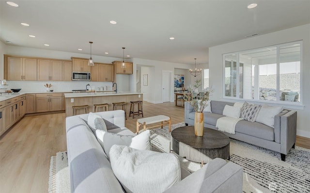 living area with light wood finished floors, a chandelier, recessed lighting, and visible vents