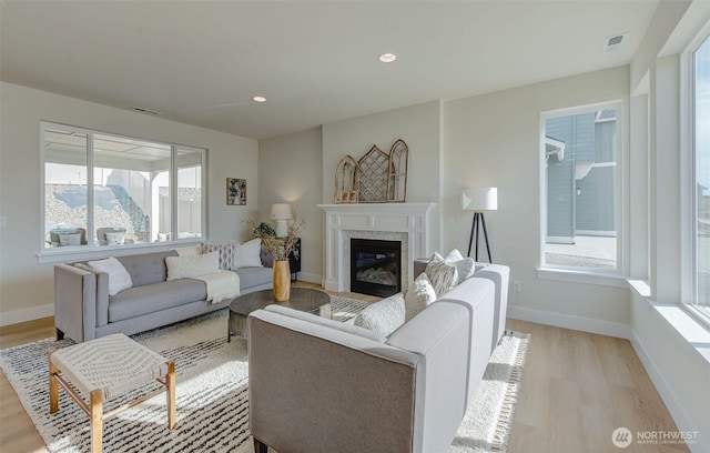 living area with a wealth of natural light, visible vents, recessed lighting, and light wood finished floors