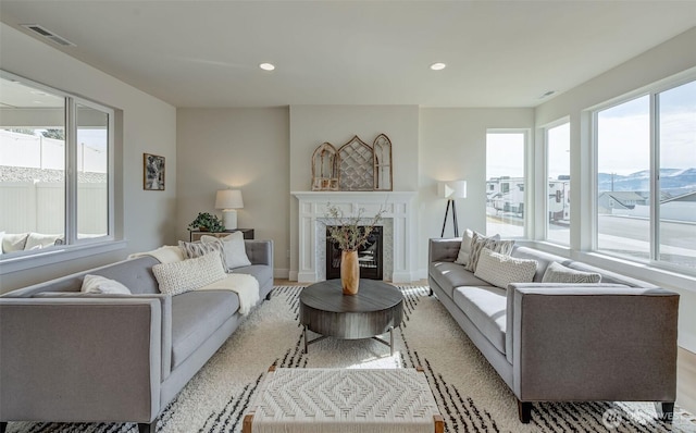 living area with recessed lighting, visible vents, and a premium fireplace