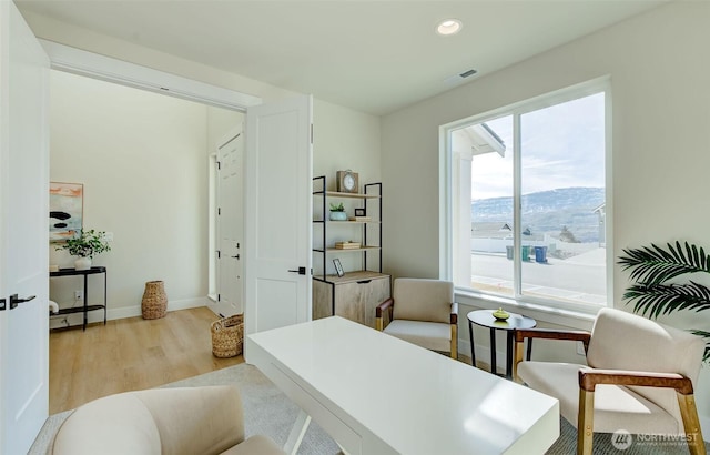 interior space featuring visible vents, baseboards, recessed lighting, light wood-style flooring, and a mountain view