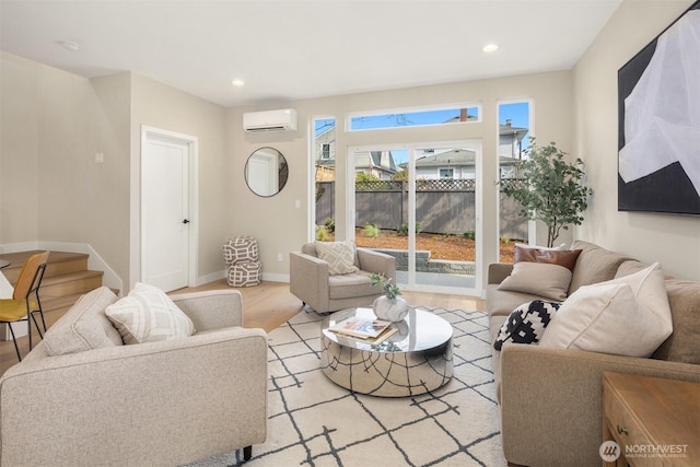 living room featuring baseboards, stairway, a wall mounted air conditioner, light wood-style floors, and recessed lighting