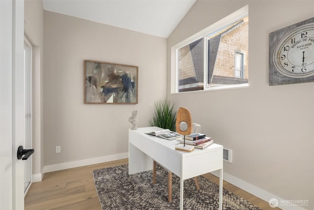 home office with lofted ceiling, visible vents, baseboards, and wood finished floors