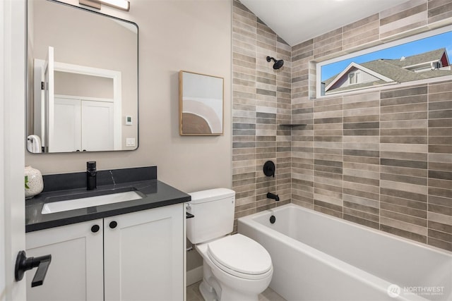 bathroom featuring vaulted ceiling, shower / washtub combination, vanity, and toilet