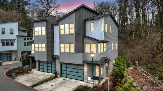 contemporary house featuring a garage, concrete driveway, and board and batten siding