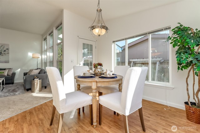 dining space featuring light wood-style floors and baseboards