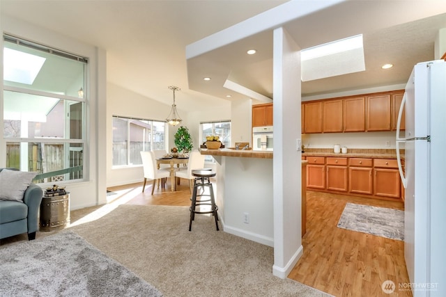 kitchen featuring open floor plan, white appliances, recessed lighting, and a kitchen breakfast bar