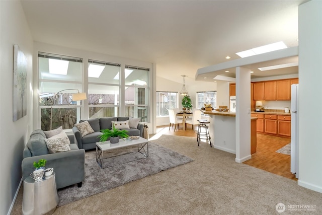 living room featuring lofted ceiling, recessed lighting, baseboards, and light colored carpet