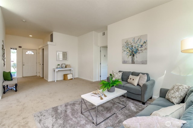 living area with carpet floors, visible vents, and baseboards