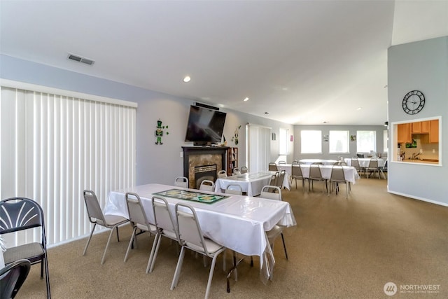 dining space featuring recessed lighting, carpet floors, a fireplace, visible vents, and vaulted ceiling