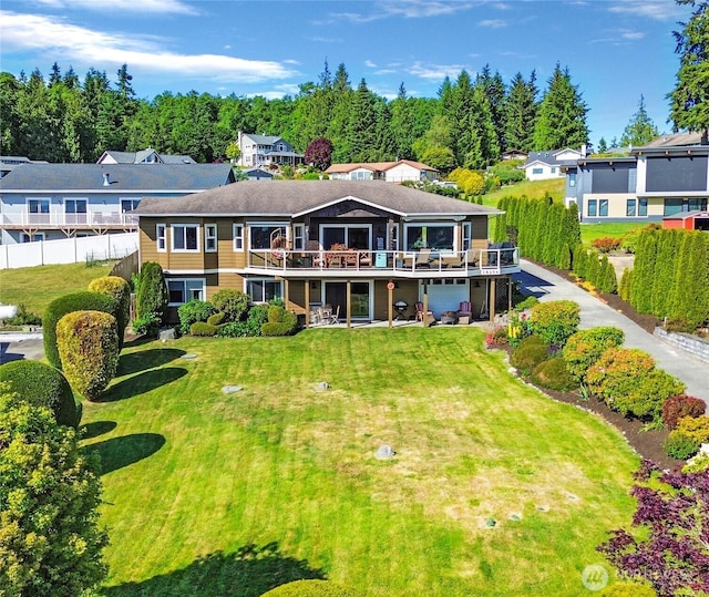 rear view of property with a deck, a lawn, and fence