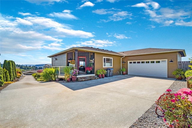 view of front of property with concrete driveway, an attached garage, and fence