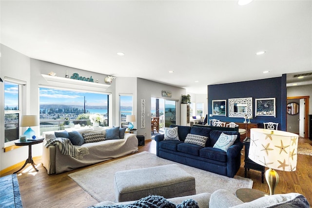 living room with recessed lighting, visible vents, baseboards, and wood finished floors