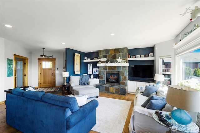 living area with a fireplace, recessed lighting, and wood finished floors