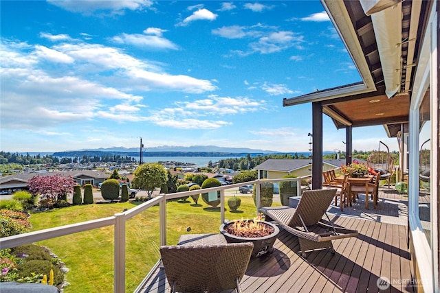 deck with a mountain view, a fire pit, and a yard