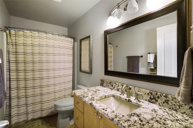 bathroom featuring vanity, curtained shower, and toilet