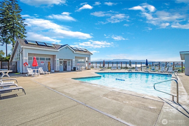 community pool featuring fence and a patio area