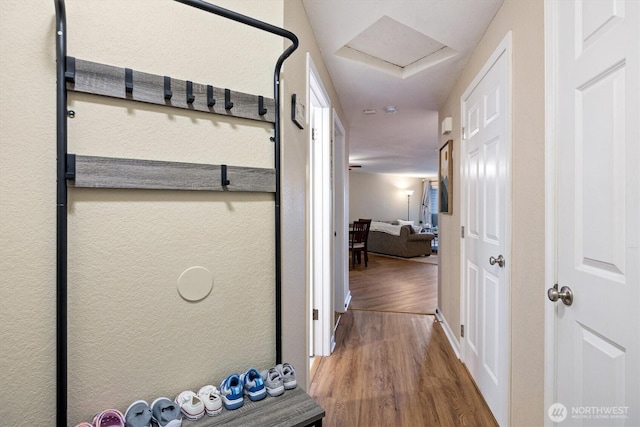 hall featuring attic access and wood finished floors