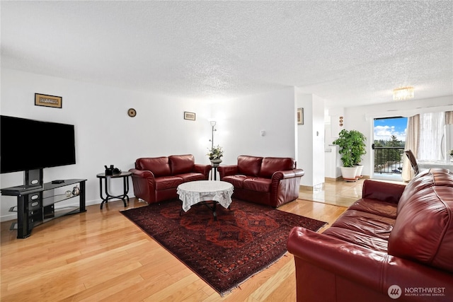 living area with light wood-style flooring and a textured ceiling