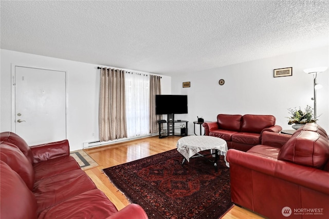 living room with light wood finished floors, baseboard heating, and a textured ceiling