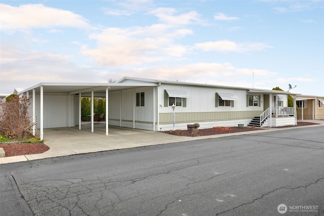 manufactured / mobile home with concrete driveway and an attached carport