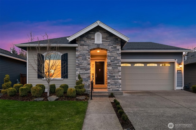 view of front facade featuring concrete driveway, stone siding, roof with shingles, an attached garage, and a yard