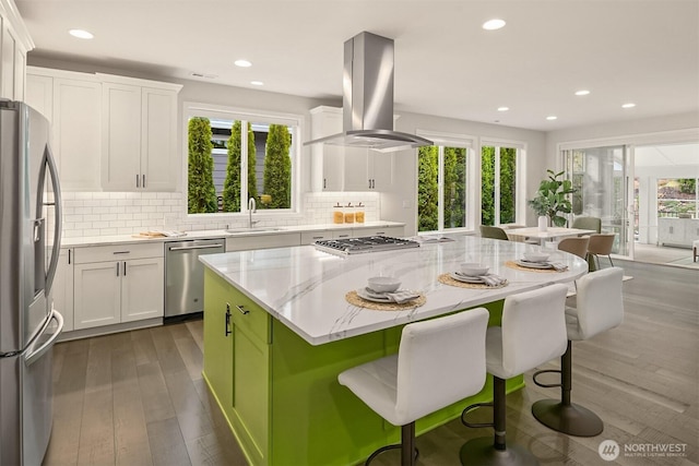 kitchen with stainless steel appliances, a center island, white cabinets, and island range hood