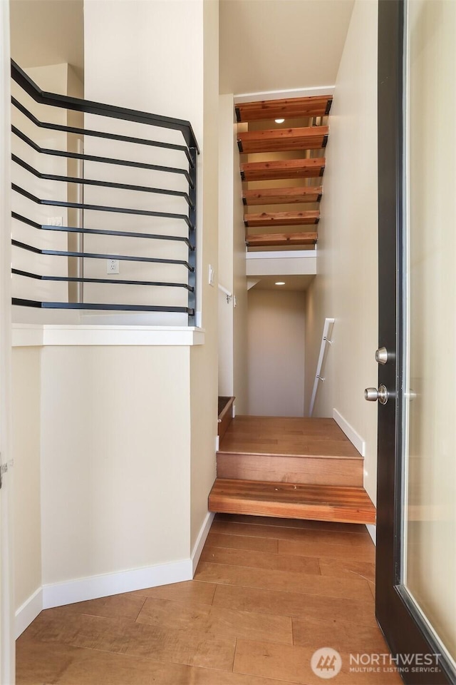 stairway featuring baseboards and wood finished floors