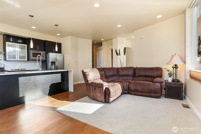 living room featuring baseboards, wood finished floors, visible vents, and recessed lighting