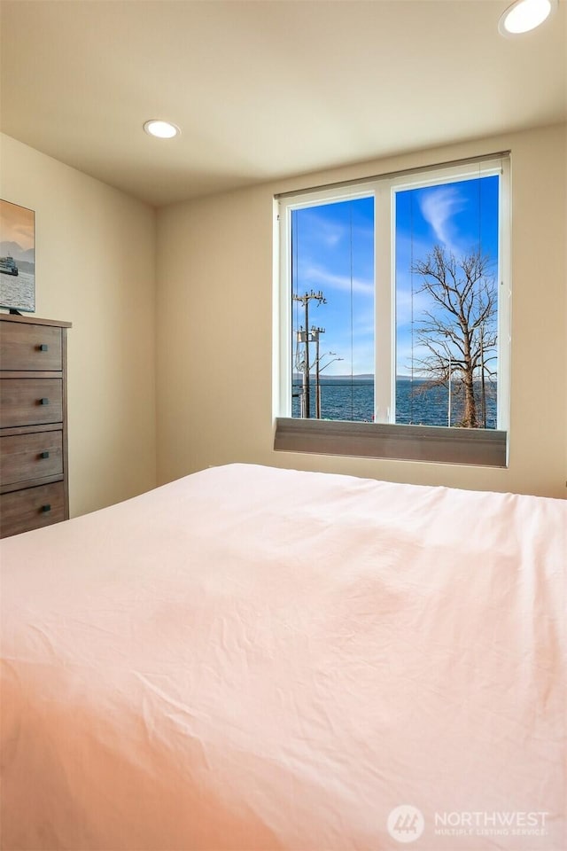 unfurnished bedroom featuring recessed lighting and a water view