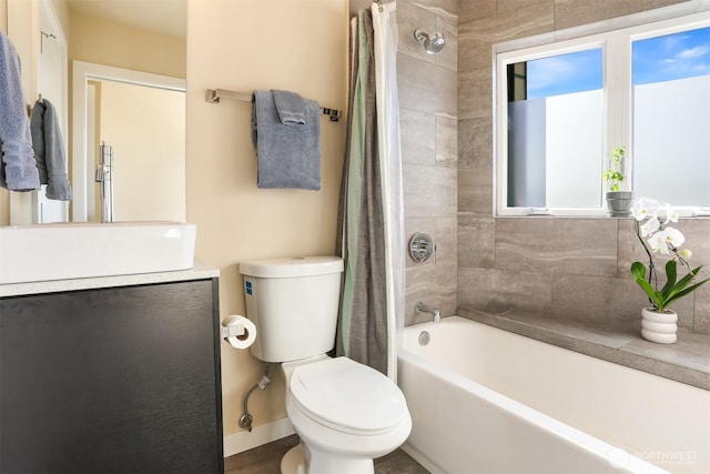 bathroom featuring vanity, shower / bath combo with shower curtain, toilet, and baseboards