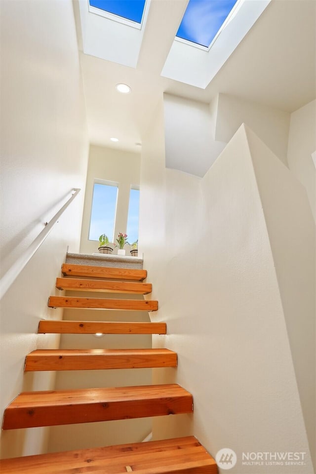 stairs with a skylight and recessed lighting