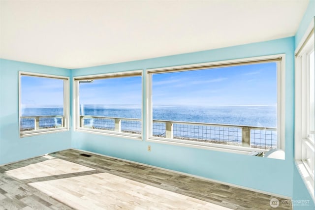 unfurnished sunroom with a water view