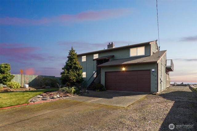 traditional home featuring fence, driveway, a chimney, a shingled roof, and a garage