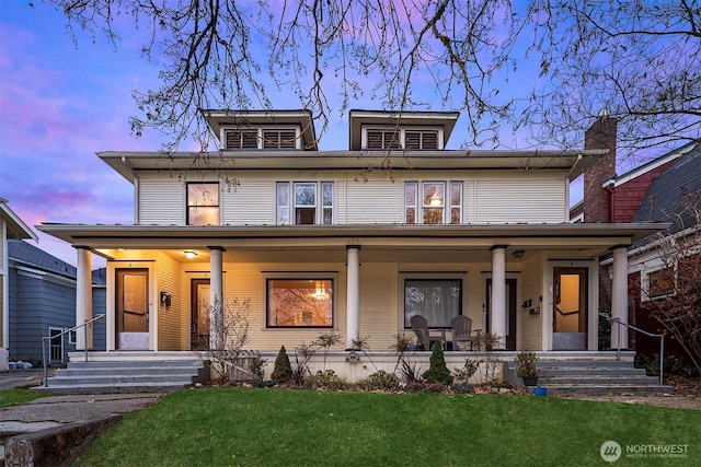 traditional style home featuring covered porch and a front lawn