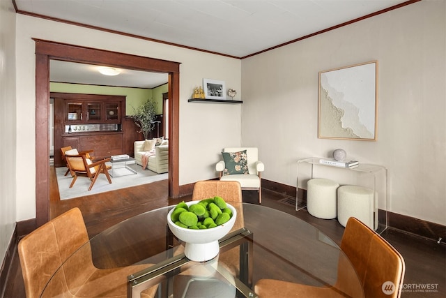 interior space with baseboards, ornamental molding, and wood finished floors