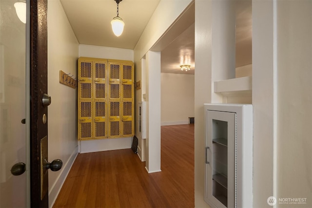 hall with dark wood-style floors and baseboards