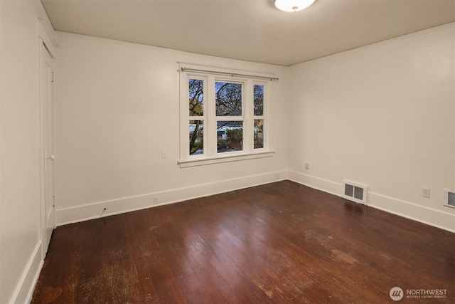 spare room with dark wood-style floors, baseboards, and visible vents