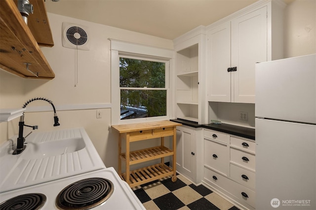 kitchen featuring light floors, open shelves, visible vents, freestanding refrigerator, and white cabinetry