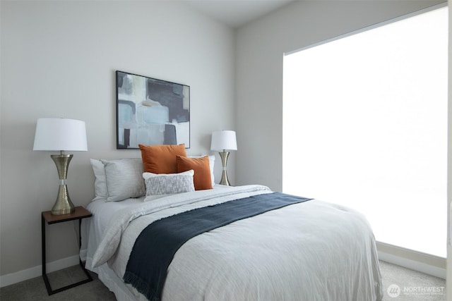 bedroom featuring light carpet and baseboards