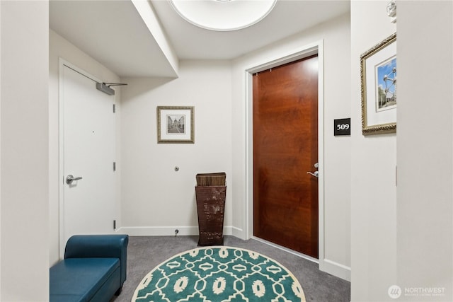 carpeted entryway featuring baseboards