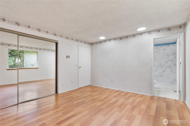 empty room with a textured ceiling and wood finished floors