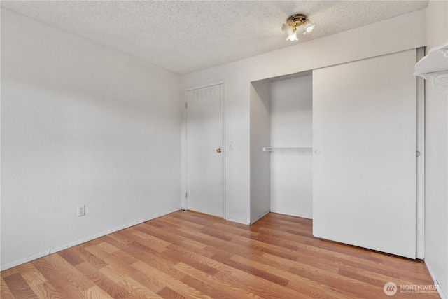 unfurnished bedroom featuring a textured ceiling and wood finished floors