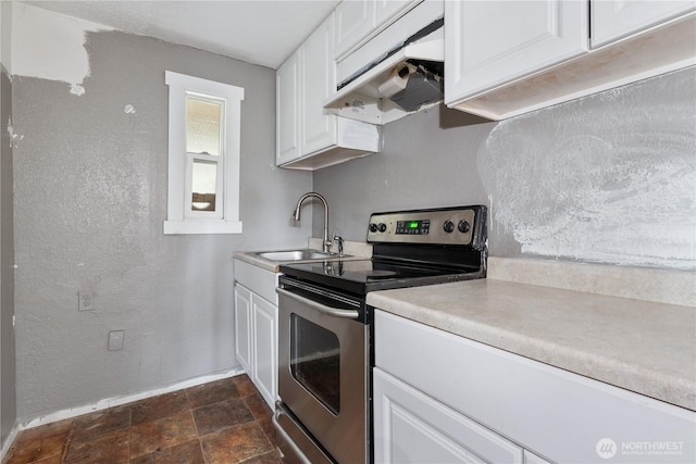 kitchen featuring a sink, stainless steel range with electric stovetop, light countertops, and under cabinet range hood