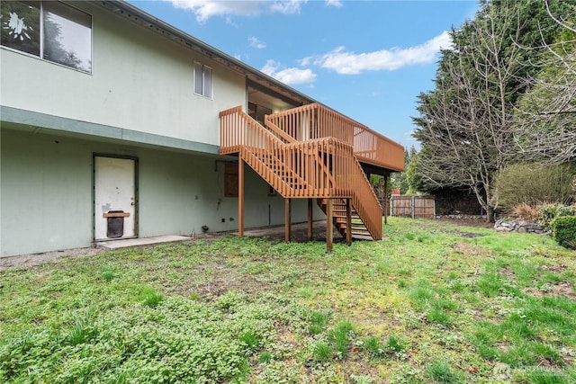 back of property featuring a yard, stairway, a deck, and fence