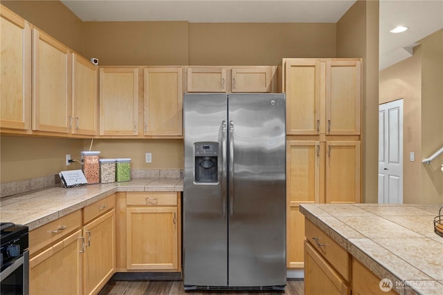 kitchen featuring stainless steel fridge, electric stove, and light brown cabinetry