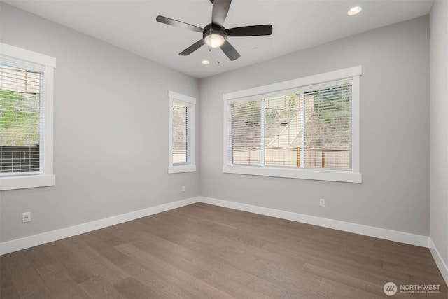 spare room featuring recessed lighting, baseboards, a wealth of natural light, and wood finished floors