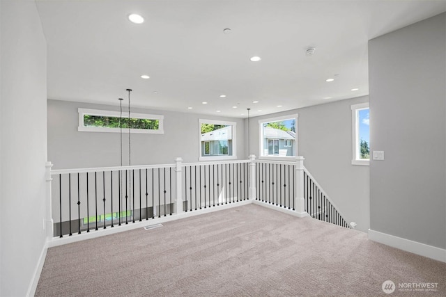 carpeted spare room with recessed lighting, baseboards, and a wealth of natural light