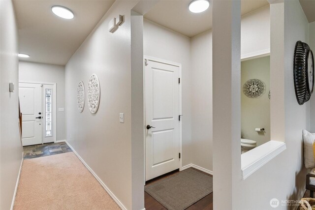 corridor featuring carpet flooring and baseboards