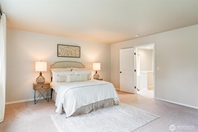 bedroom with light colored carpet and baseboards